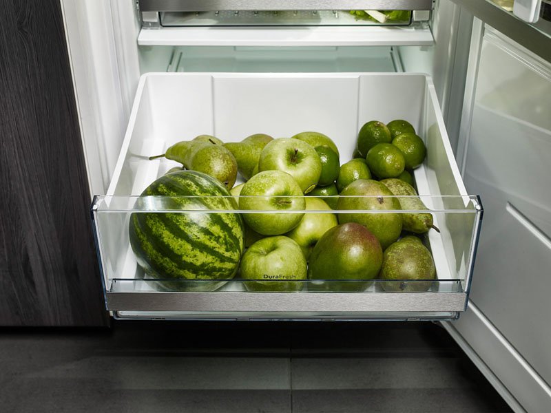 Udtrukket skuffe med æbler og vandmelon i et Asko skab