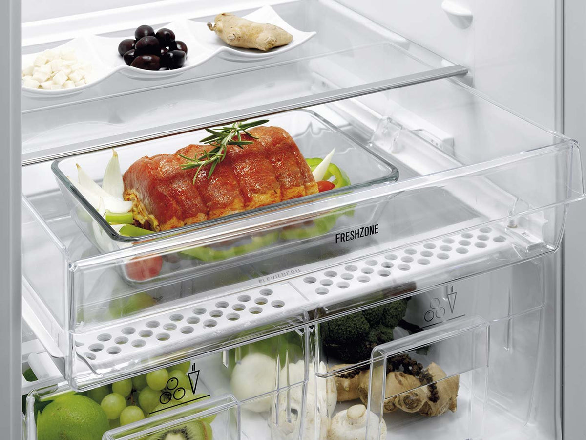 Hylde med steg og grøntsager i FreshZone-skuffen i et Electrolux køleskab