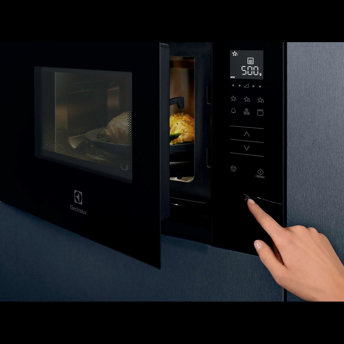Finger trykker på betjeningspanelet på en indbygget Electrolux mikroovn