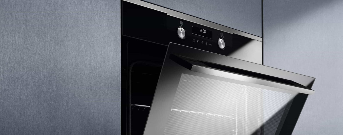 Indbygget Electrolux ovn med åben låge i et køkken med grå skabe