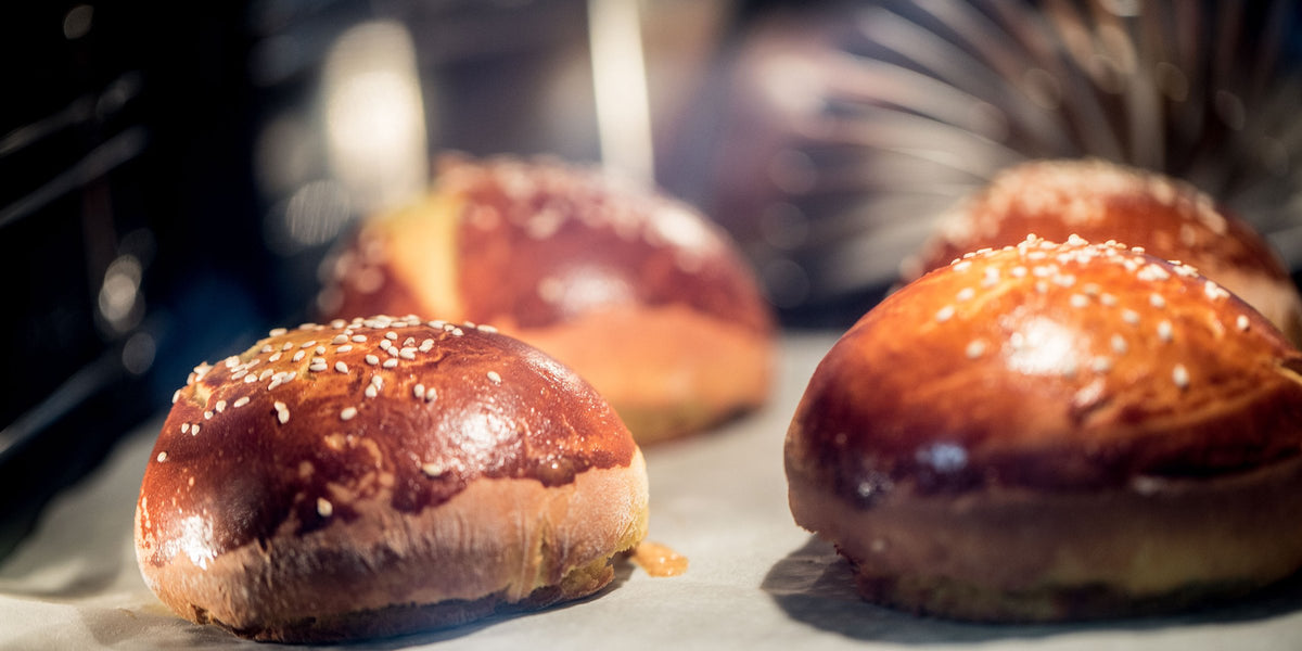 Bagte boller med sesam på en bageplade
