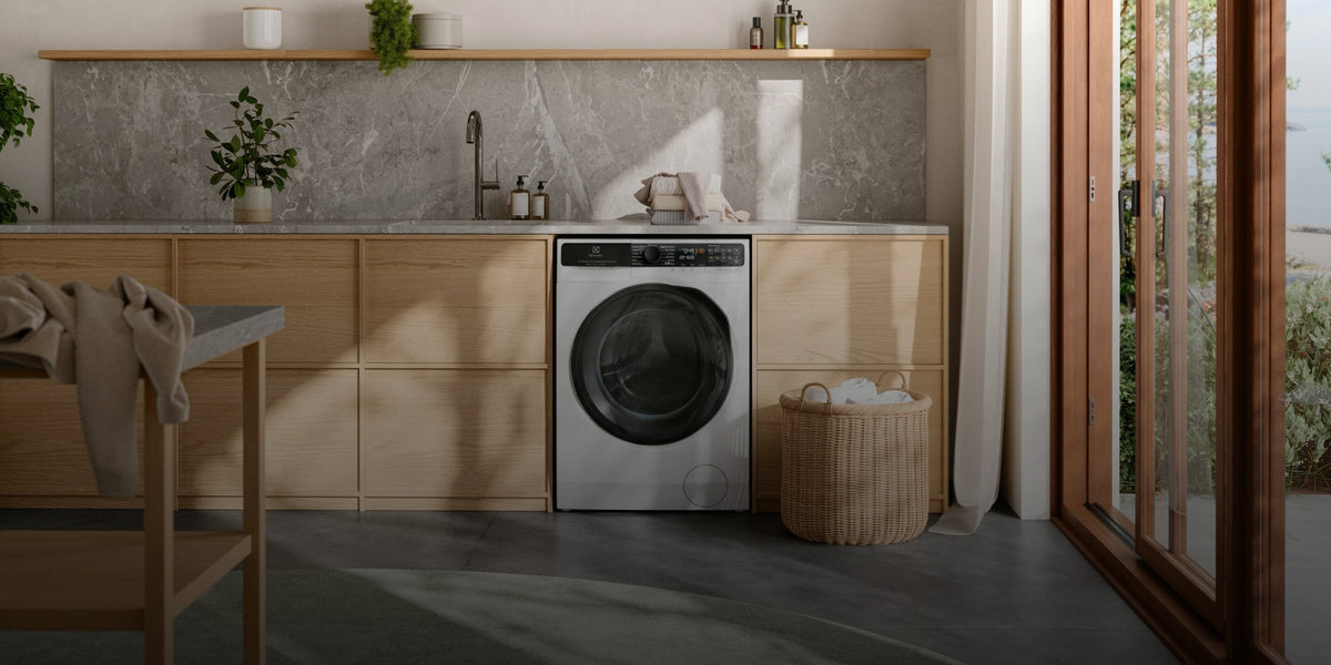 Electrolux vaske-tørremaskine under en bordplade i et lyst bryggers