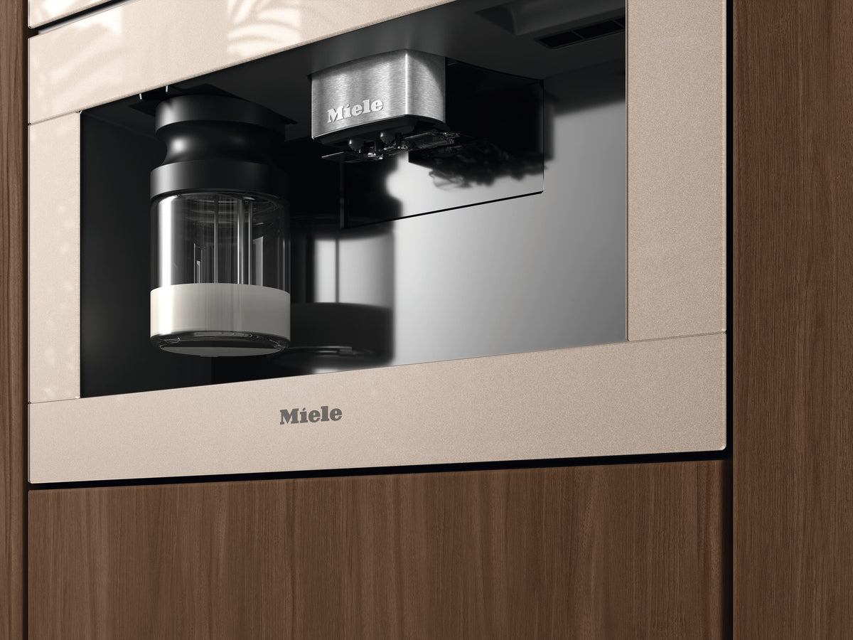 Indbygget Miele espressomaskine i pearlbeige i et højskab med træfront