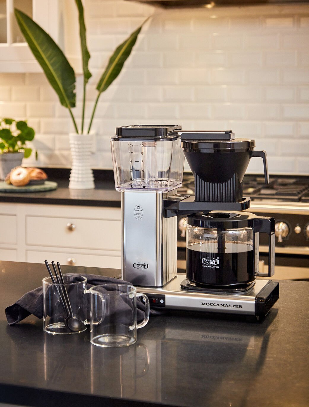 Moccamaster Automatic kaffemaskine på en bordplade ved siden af kaffekopper