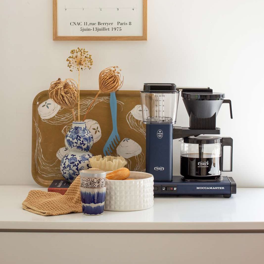 Moccamaster Optio i Midnight Blue på en lys bordplade med dekorationer
