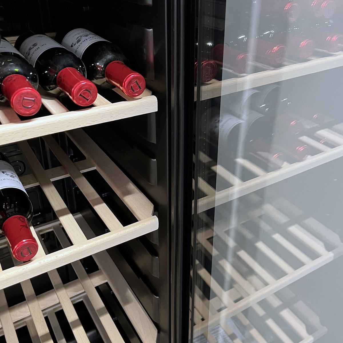 Vinflasker på bøgehylder i et Scandomestic vinkøleskab