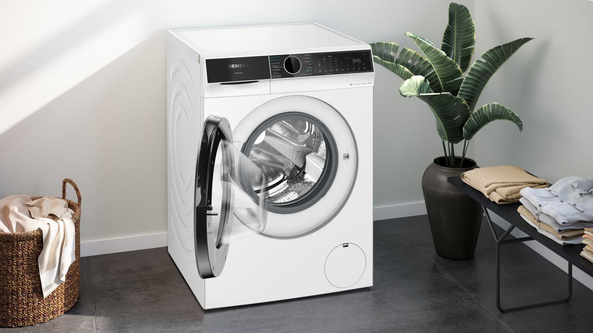 Siemens vaske-tørremaskine med åben låge ved siden af en plante